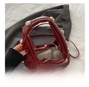 Vue détaillée de la capacité intérieure du sac à main en cuir bordeaux clouté