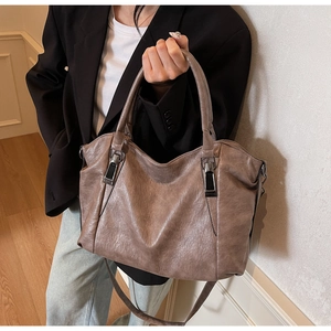 Sac fourre-tout en cuir marron avec texture lychee et boucles métal sur modèle