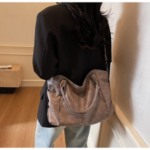 Brown faux leather tote bag showing large capacity and adjustable shoulder strap detail
