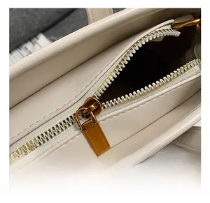 Close-up of premium gold-tone metal zipper and smooth leather texture on women's bucket bag