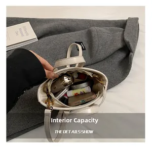 Interior view of spacious cream bucket bag showing storage for phone and cosmetics