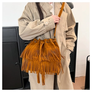 Brown suede bucket bag detail featuring double-layered fringe and drawstring closure