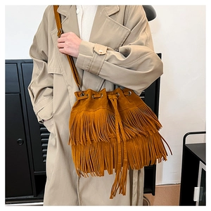 Detail of tan suede bucket bag with long double tassels and drawstring closure