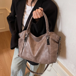 Grand sac cabas en cuir souple marron avec bandoulière présenté dans un décor intérieur