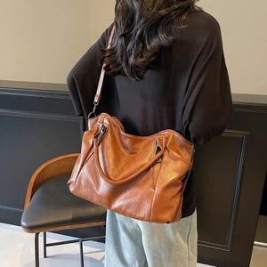 Grand sac à main en cuir PU marron avec bandoulière, porté par un mannequin femme