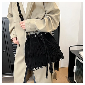 Close-up of black suede bucket bag with long double-layer tassels and drawstring detail