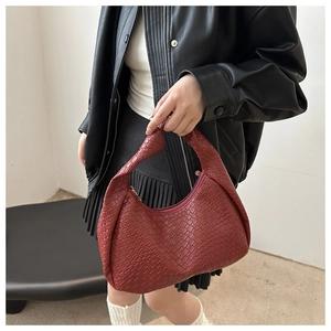 Detail of red woven texture on hobo shoulder bag with zipper closure and leather handle