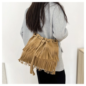 Detail of tan suede bucket bag featuring long double-layer fringes and drawstring closure
