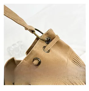 Detail of bronze hardware and drawstring on vintage brown suede tassel bucket bag