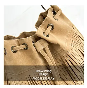 Close-up of drawstring closure and retro metal eyelets on a camel suede tassel bucket bag