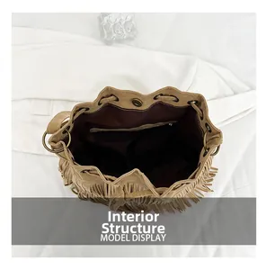 Interior detail of khaki suede bucket bag featuring drawstring closure and zipper pocket
