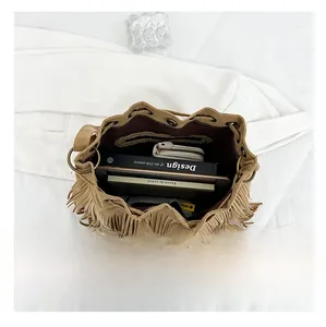 Top view of brown suede bucket bag interior showing spacious capacity for books and wallet