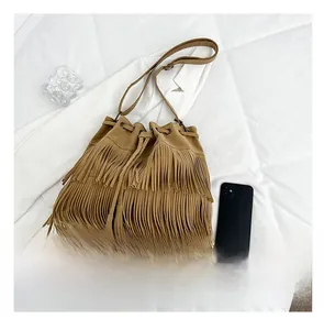 Top view of brown suede tassel bucket bag showing scale next to a smartphone