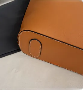 Close-up of tan leather tote bag base with reinforced oval panel and white stitching