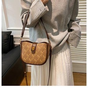 Retro saddle bag featuring horse patterns and brown leather details shown on a model