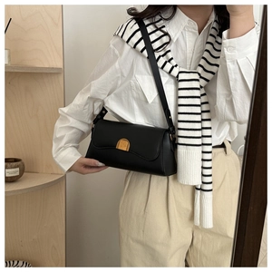 Détail du sac vintage en cuir noir avec une boucle demi-lune dorée rétro pour femme