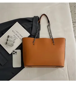 Detail shot of the large capacity tote bag bottom with protective metal feet and chain strap