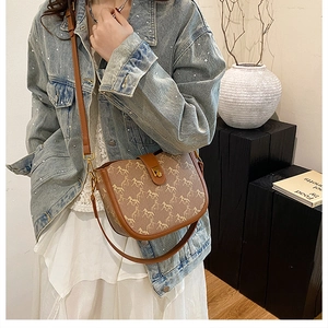 Detailed view of the brown saddle bag with horse pattern and vintage metal buckle