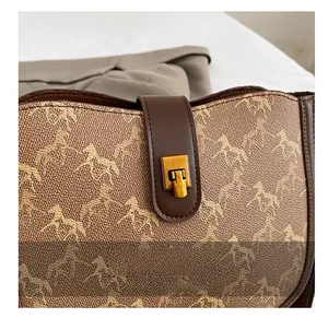 Close-up of vintage saddle bag featuring a classic horse pattern and golden metal buckle