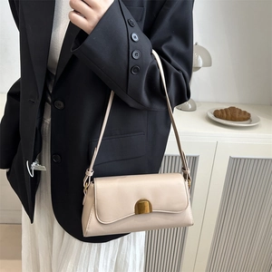 Sac baguette beige chic avec boucle dorée dans un décor de style de vie minimaliste