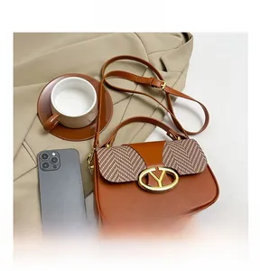Detail shot of a brown color-block handbag featuring a houndstooth pattern and a gold Y-buckle