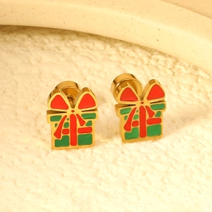 Macro view of gold-plated Christmas gift box earrings with red and green enamel finish