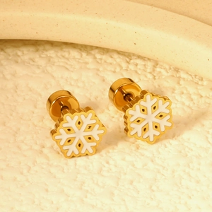 Macro detail of gold snowflake earrings with white enamel finish and screw back design