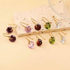 Minimalist round crystal hook earrings in five colors on a textured stone surface