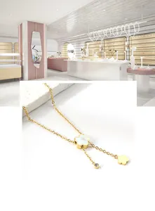 Detail der Kleeblatt-Kette mit weißer Muschel-Einlage und elegantem Gold-Quasten-Design