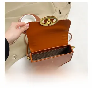 Detailed interior of the brown leather handbag with gold magnetic ring clasp and fabric lining