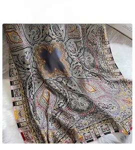Gros plan d'un foulard en soie à motif paisley posé sur un tapis blanc en peluche