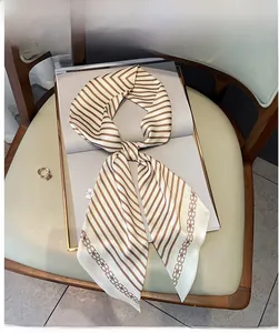 Gros plan d'un foulard en soie rétro à rayures et motifs de chaînes sur un magazine blanc