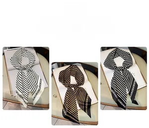Détail de foulards en soie rayés avec bordures de chaîne en noir, blanc et marron