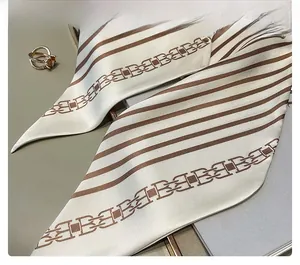 Détail d'un foulard en soie rayée avec motif chaîne et finition de couture interne