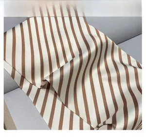 Détail d'un foulard en soie avec des rayures diagonales marron et beige et aspect satiné