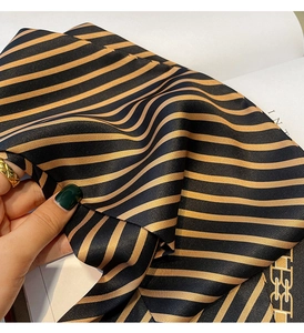 Gros plan du foulard en soie rayé montrant la texture satinée et les coutures fines