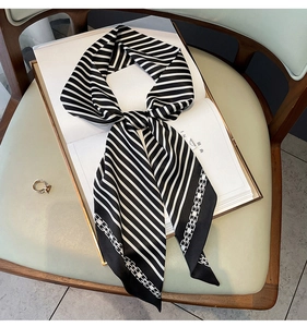 Détail d'un foulard en soie à rayures noires et blanches avec motif de chaîne sur un magazine