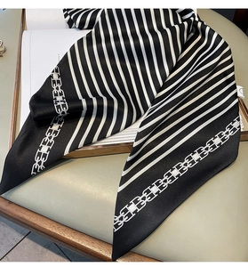 Détail d'un foulard en soie rayé avec motif lettre B sur un fond en cuir élégant
