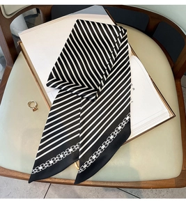 Détail d'un foulard en soie à rayures noires et blanches sur un fauteuil