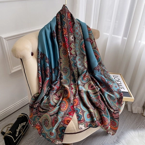 Écharpe en soie à motif paisley bleu drapée sur un fauteuil au style vintage chic