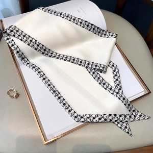 Detail of elegant cream satin twilly scarf with black and white houndstooth trim