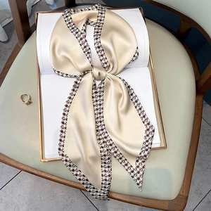 Champagne silk-like skinny scarf with brown houndstooth border tied on book