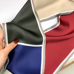 Detail of high-quality satin scarf featuring a bold geometric color-block pattern