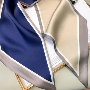 Macro detail of silky polyester neck scarf with modern geometric color block patterns
