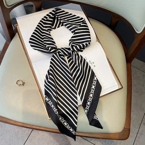 Foulard en soie à rayures noires et blanches avec motif chaîne sur un livre