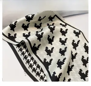 Detail of silk-like scarf featuring houndstooth heart print and black borders