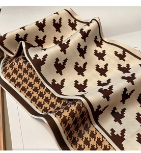 Macro detail of houndstooth silk scarf showing smooth satin texture and fold lines