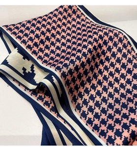 Macro shot of houndstooth silk scarf with pink and navy blue pattern and elegant texture