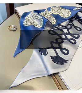 Gros plan d'un foulard en soie aux motifs nautiques et élégante finition de couture interne