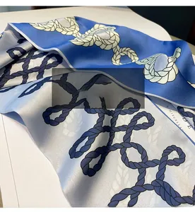 Détail d'un foulard en soie bleu à motif corde nautique avec finition satinée